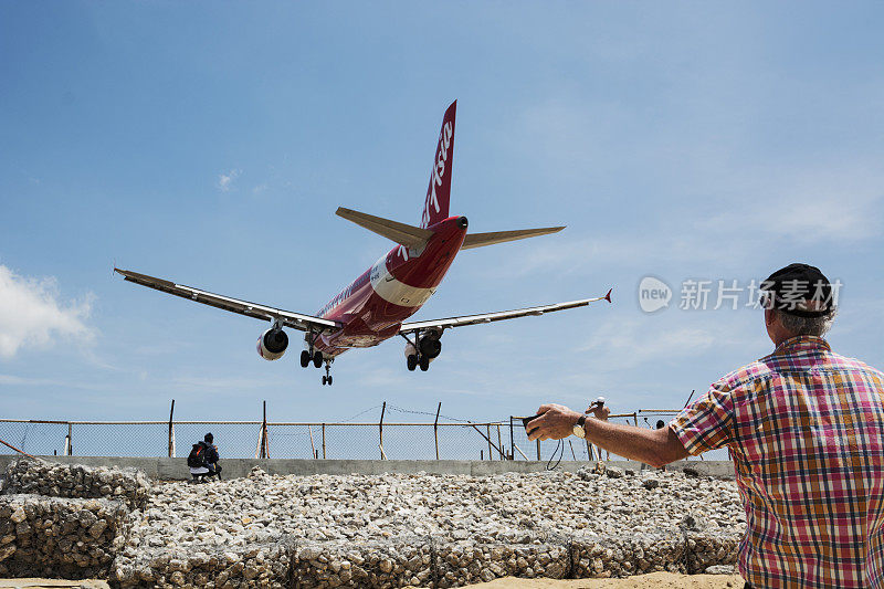 亚航900 - ahs(空客A320)降落泰国普吉岛机场。人们正在为这一刻拍照